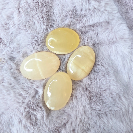 Pieni persikkakalsiitti kämmenkivi